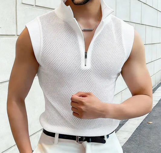 Man wearing a white sleeveless mesh shirt against a light-colored wall.